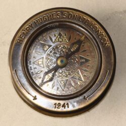Close-up of the antique-style compass dial, showing the detailed compass rose and historical engravings.