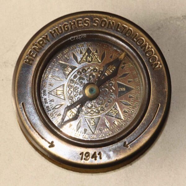 Close-up of the antique-style compass dial, showing the detailed compass rose and historical engravings.