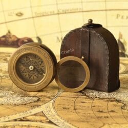 Brass compass and flip-up magnifier fully removed from their stitched brown leather carrying case.