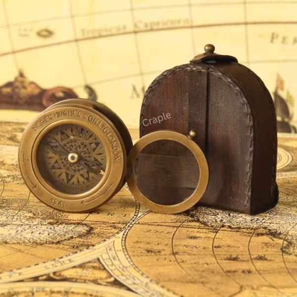 Brass compass and flip-up magnifier fully removed from their stitched brown leather carrying case.