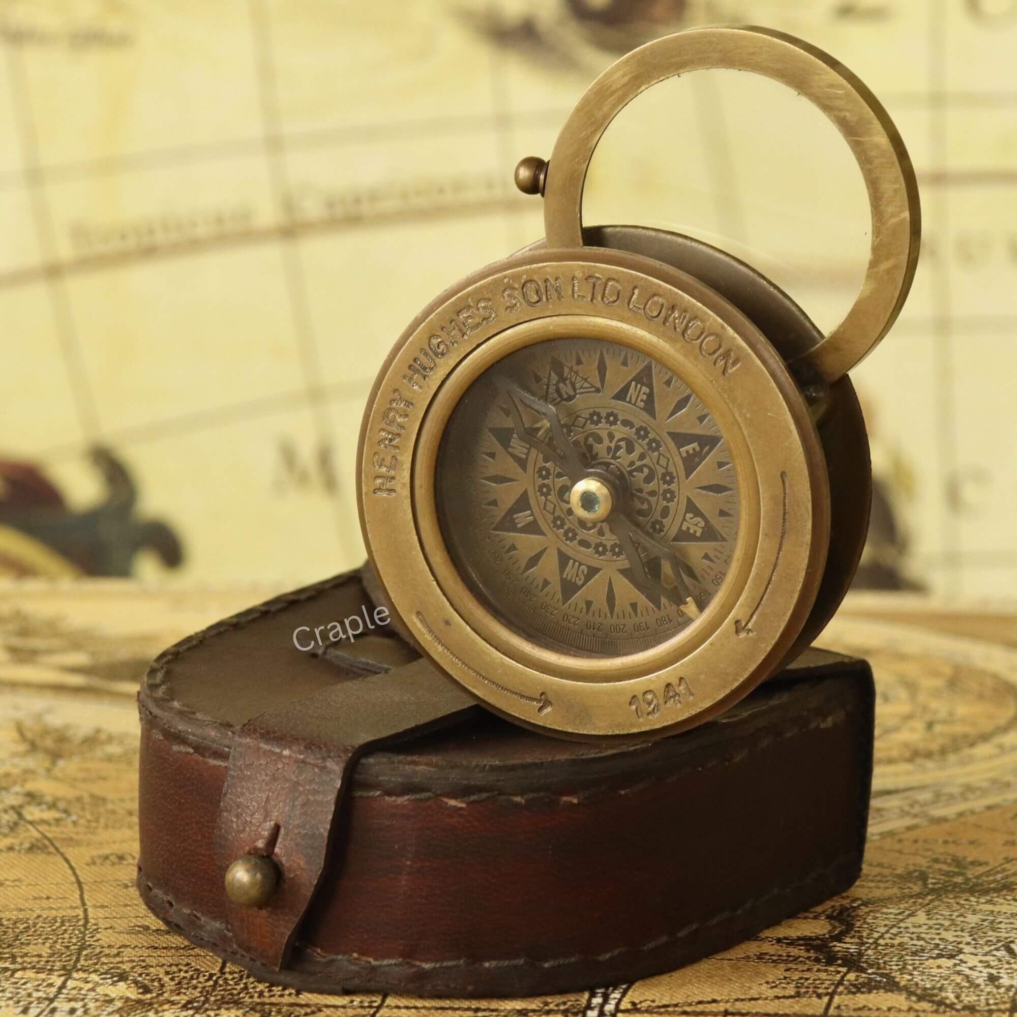 Sliding Magnifier Desk Compass-5 Antique brass sliding desk compass with its flip-up magnifier open, emerging from a stitched leather case.