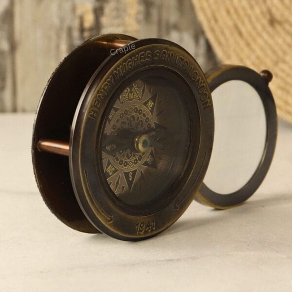 Side profile of the brass pocket compass, showing the sliding mechanism for the integrated magnifying glass.