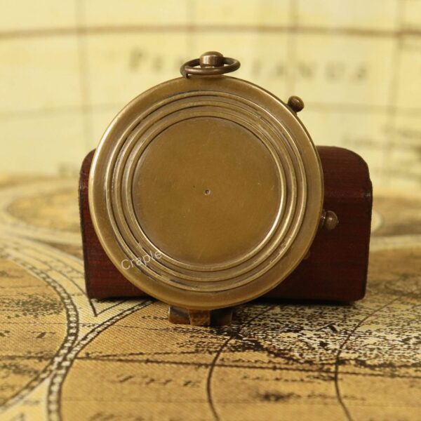 Side profile of the closed antique brass pocket compass, showing the hinge and the loop for a chain.