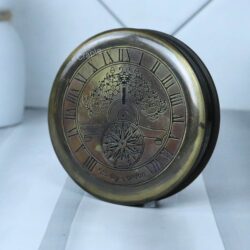 Side profile of the round Stanley London brass compass, highlighting its portable, pocket-watch style.