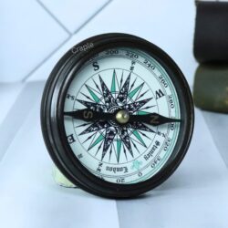Angled view of the open Stanley London compass, focusing on the detailed compass rose and directional needle.