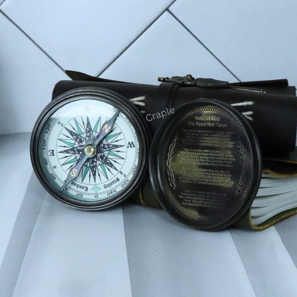 Open Stanley London pocket compass with a black antique finish, displaying the internal compass dial and the engraved lid.