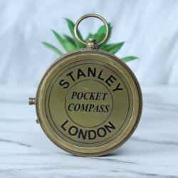Top-down view of the closed Stanley London compass, showing the engraved lid and the top attachment ring.