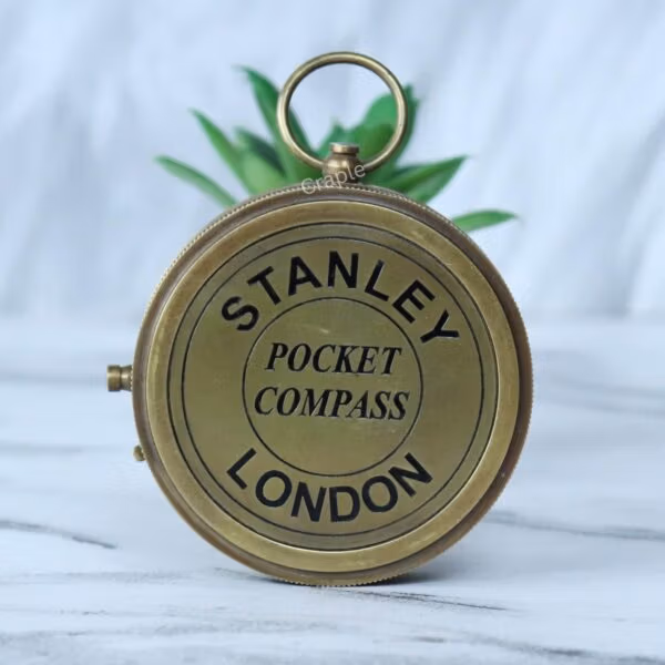 Top-down view of the closed Stanley London compass, showing the engraved lid and the top attachment ring.