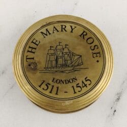 Close-up of the polished brass lid engraved with "THE MARY ROSE LONDON 1511-1545" and a ship illustration.