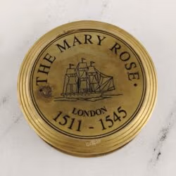 Close-up of the polished brass lid engraved with "THE MARY ROSE LONDON 1511-1545" and a ship illustration.