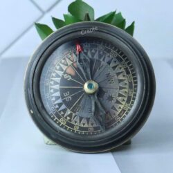The open Titanic compass revealing the vintage-style, detailed compass dial with cardinal points.