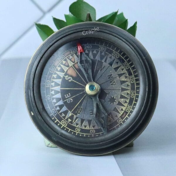 The open Titanic compass revealing the vintage-style, detailed compass dial with cardinal points.