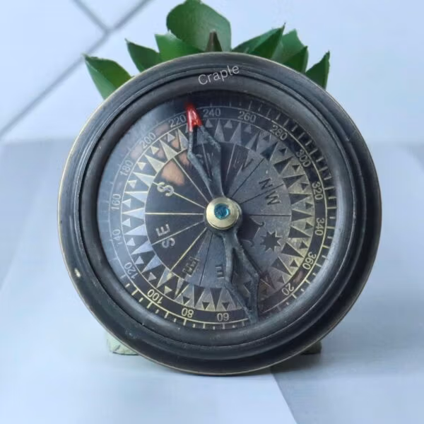 The open Titanic compass revealing the vintage-style, detailed compass dial with cardinal points.