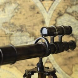 Detailed side view of the top-mounted finder scope and the main barrel of the decorative brass telescope.