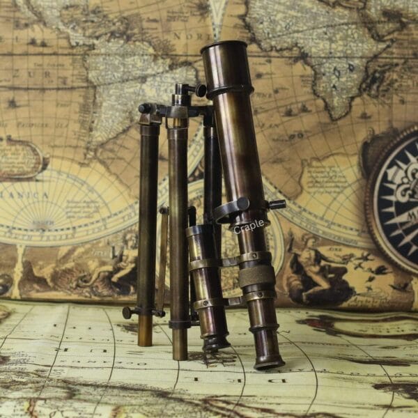 A collection of several antique-style brass telescopes standing on a vintage world map.