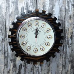 Industrial steampunk-style wall clock with a dark brown wooden frame shaped like a large gear and a vintage "Victoria London" dial.
