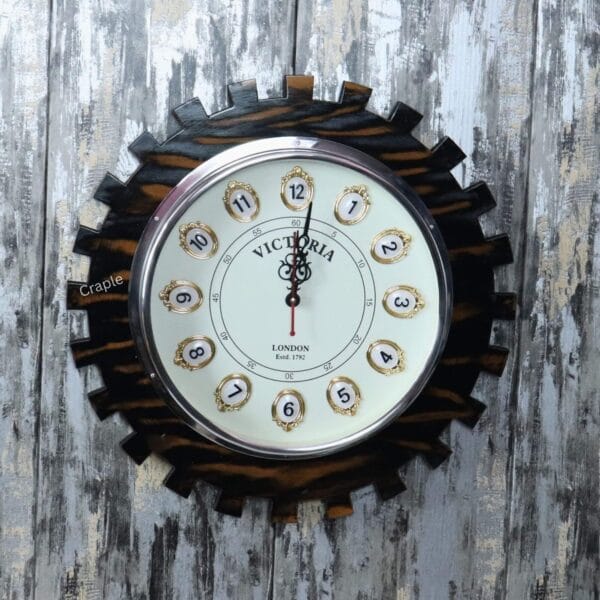 Industrial steampunk-style wall clock with a dark brown wooden frame shaped like a large gear and a vintage "Victoria London" dial.