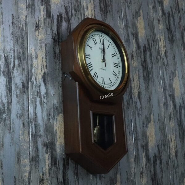 Left-angled perspective of the brass and wood pendulum clock, highlighting its depth and traditional design.