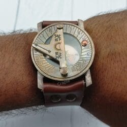 The vintage brass sundial compass being worn on a wrist, demonstrating its look as a steampunk-style accessory.