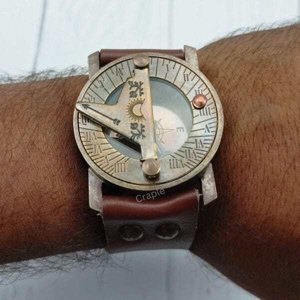 The vintage brass sundial compass being worn on a wrist, demonstrating its look as a steampunk-style accessory.