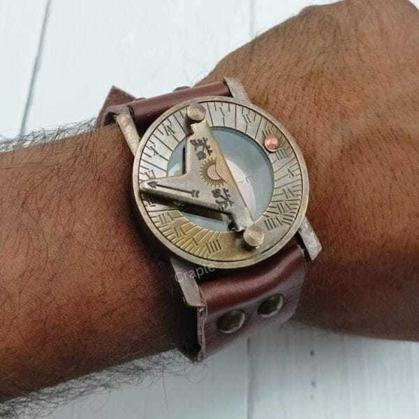 Side view of the antique brass wrist sundial compass being worn, highlighting the thick leather strap and brass casing.