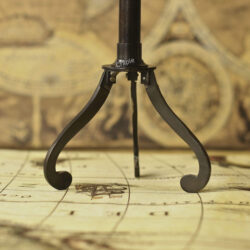 Close-up of the elegant, curved legs of the black antique finish brass tripod stand for the decorative telescope.