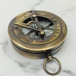 Angled view of the closed black antique sundial compass, highlighting its solid brass construction and pocket-watch style.