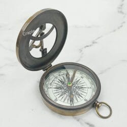 Three-quarter view of the open West London sundial compass, displaying both the lid and the compass dial.
