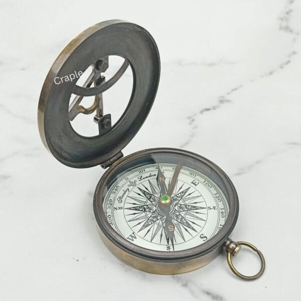 Three-quarter view of the open West London sundial compass, displaying both the lid and the compass dial.