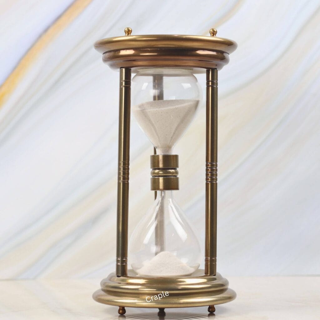 Large vintage-style 5-minute hourglass with a shiny brass finish, steel pillars, and white sand.