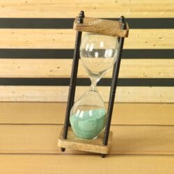 The rustic 10-minute hourglass with green sand, tilted at an angle to show its dynamic form.
