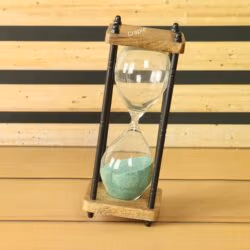 The rustic 10-minute hourglass with green sand, tilted at an angle to show its dynamic form.