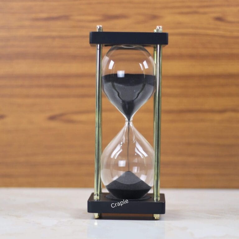 A modern 15-minute hourglass with black sand, framed by black wooden bases and nickel-plated brass pillars.