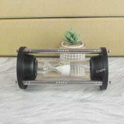 The 3-minute floating steel hourglass resting horizontally, showcasing its durable black and steel construction.