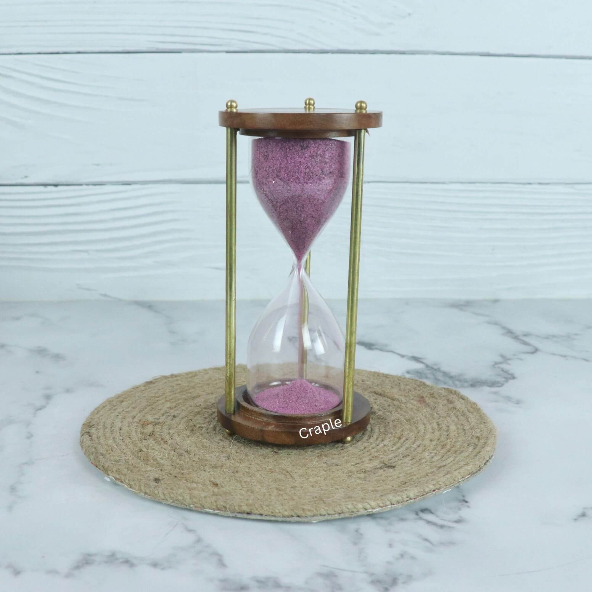 3-Minute Wood & Brass Sand Timer-1 A vintage 3-minute hourglass with purple sand, framed by round wooden bases and classic brass pillars.