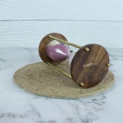 Angled view of the 3-minute sand timer, highlighting the rich grain of the wooden base and brass pins.