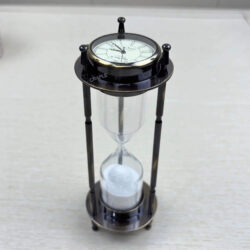 An antique brass 3-in-1 hourglass, featuring a vintage clock on top and a compass on the bottom.