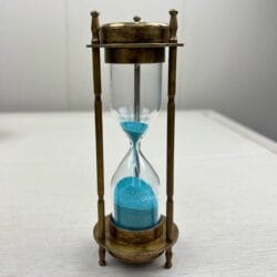 Front view of the antique gold brass hourglass with vibrant blue sand, showing the 3-minute sand timer.