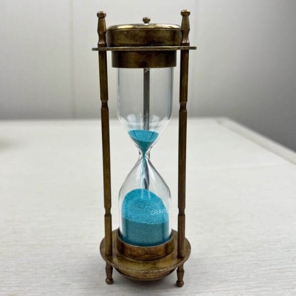 Front view of the antique gold brass hourglass with vibrant blue sand, showing the 3-minute sand timer.