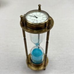 Antique brass 3-in-1 desktop accessory showing the vintage-style clock face on top of the blue sand hourglass.
