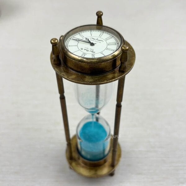 Antique brass 3-in-1 desktop accessory showing the vintage-style clock face on top of the blue sand hourglass.