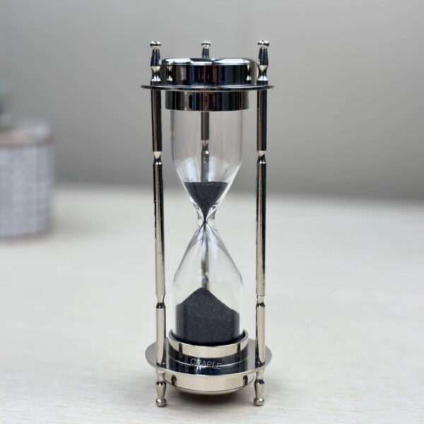 Side profile of the 3-minute black sand timer with its nickel-finish brass frame standing upright.