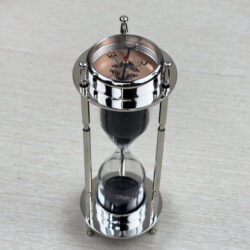 A multifunctional 3-in-1 desktop tool featuring a black sand hourglass, a compass, and a clock, all in a polished nickel-finish brass frame.