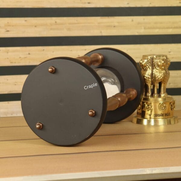 Close-up of the black wooden base of the 30-minute sand timer, showing the copper hardware details.