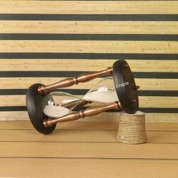 The large copper and wood hourglass used as a decorative accent piece on a desk.