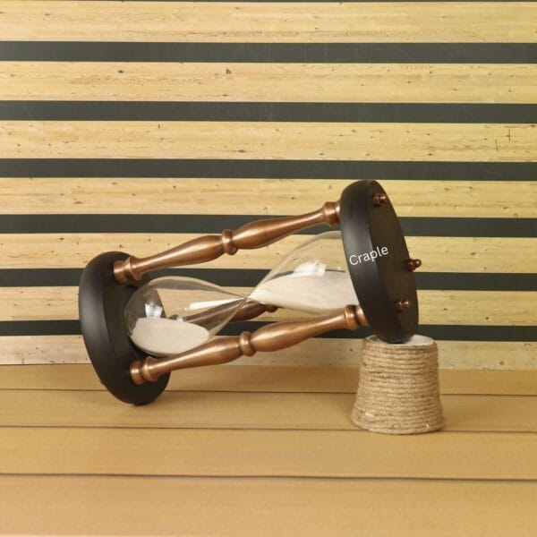 The large copper and wood hourglass used as a decorative accent piece on a desk.