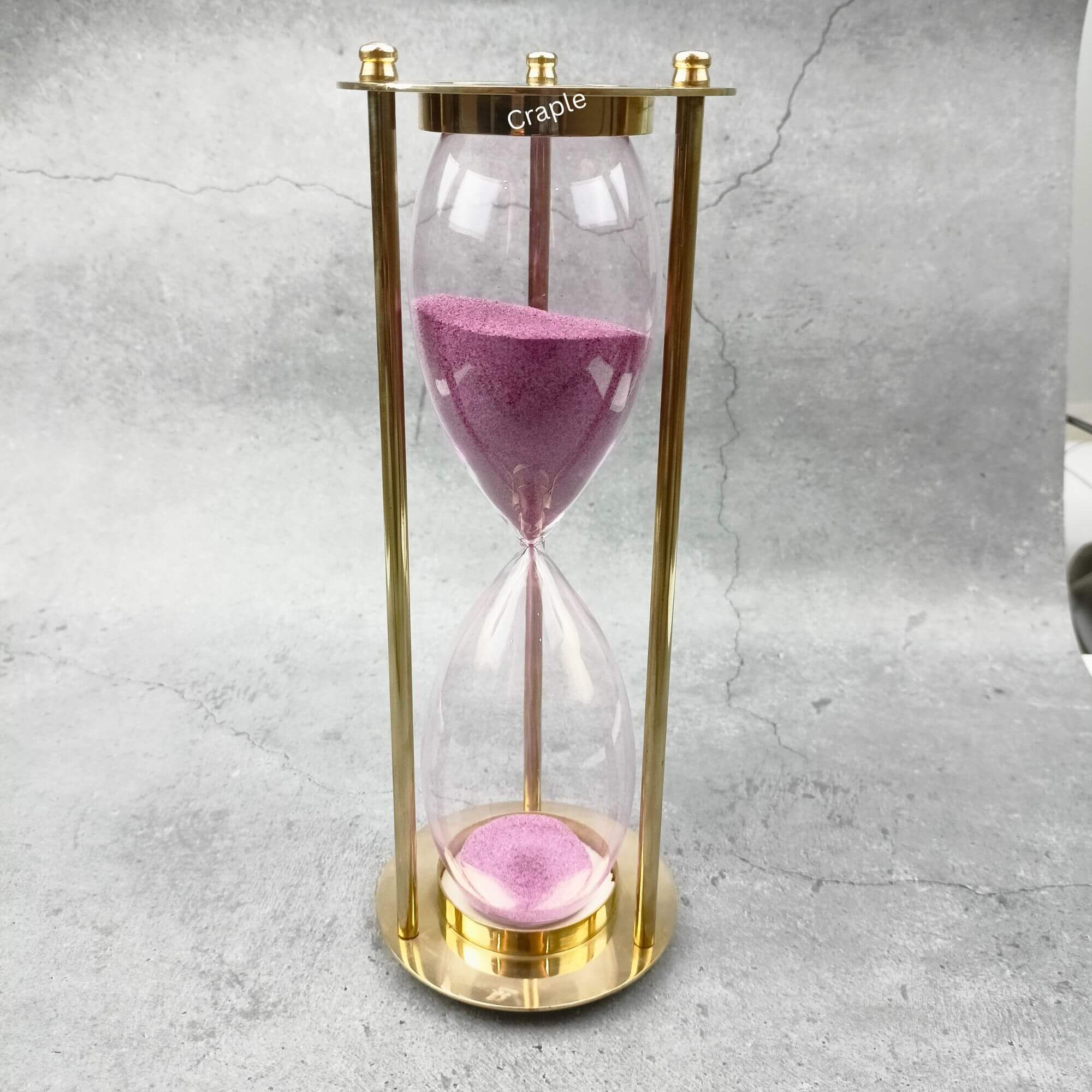 30-Minute ‘Old Sand Watch’ Sand Timer-1 Elegant 30-minute hourglass sand timer featuring a polished brass frame and vibrant light pink sand.