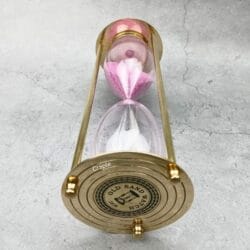 Close-up of the engraved top plate of the vintage-style brass hourglass.