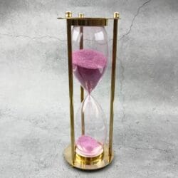 Full view of the decorative 30-minute brass sand timer with pink sand.
