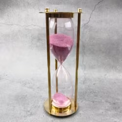 Full view of the decorative 30-minute brass sand timer with pink sand.